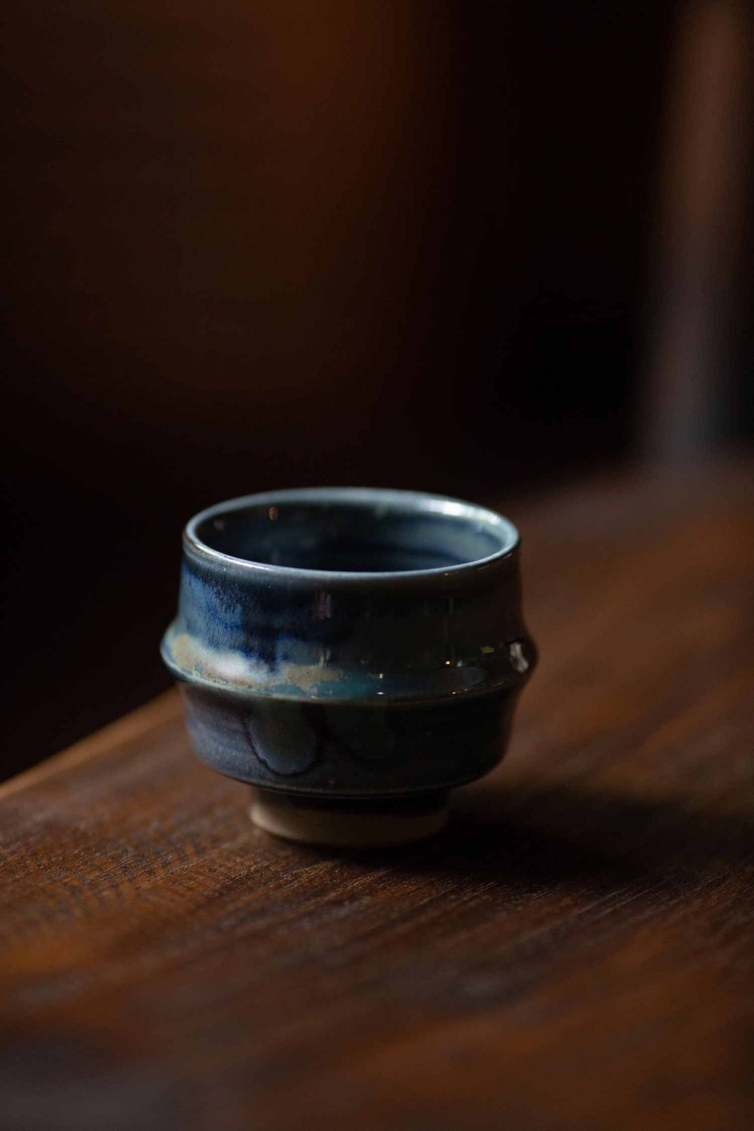 Close-up of Sake Cup with cloudy blue glaze on a wooden surface