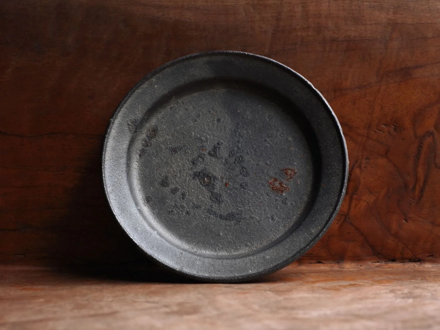 View of a plate standing against a bench showing the subtility of the glaze