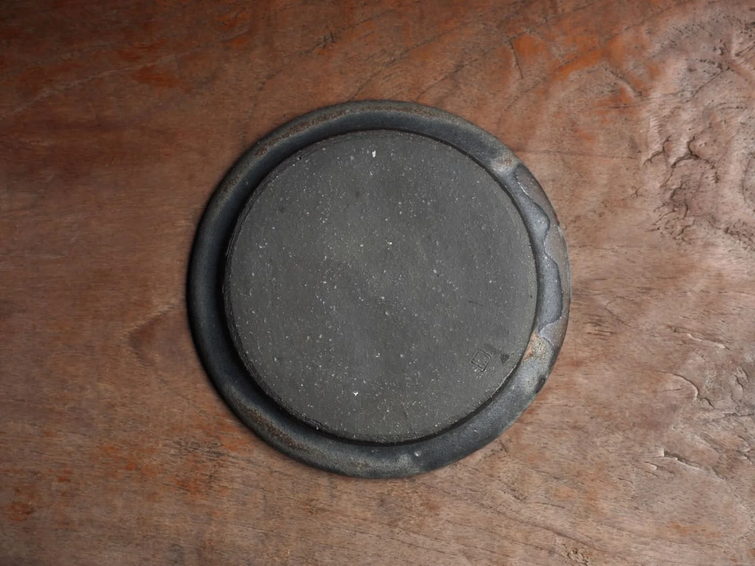 Back of a rounded plate on a bench showing the back shape