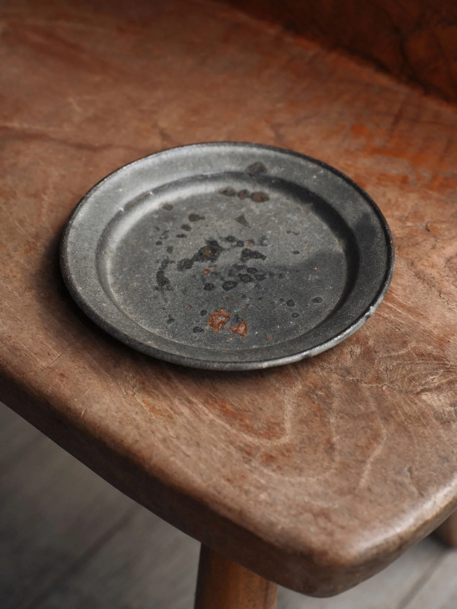 grey plate on a wood view taken from above showing subtle glazes