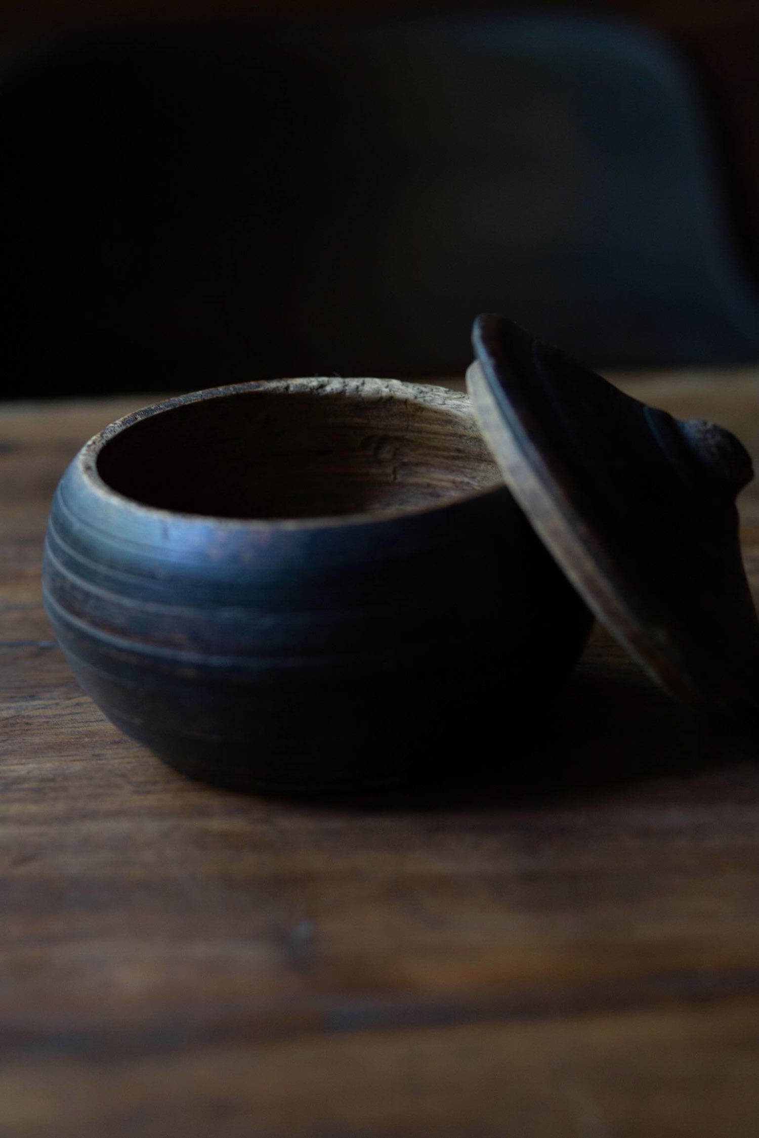 Close-up of open carved wooden container, interior wood grain and hand-hewn edge details visible