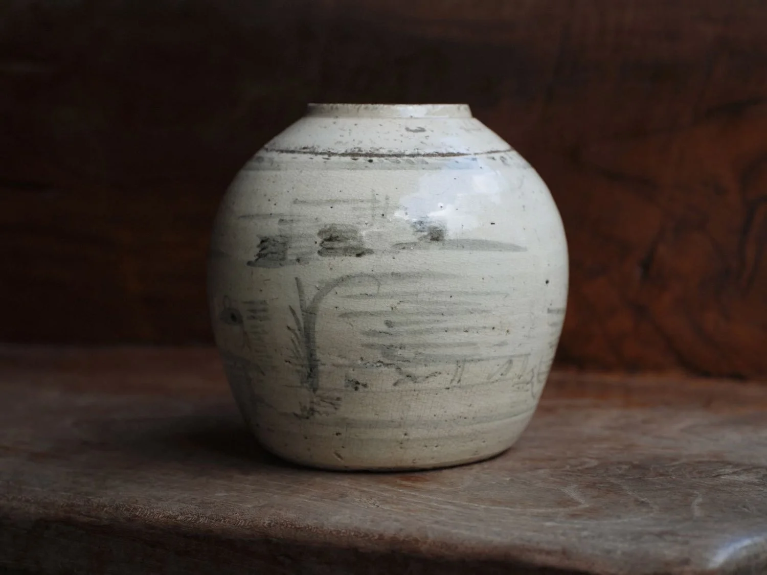 Side angle of crackle glaze stoneware vase from East Asia showing age patina and hand-painted botanical motif