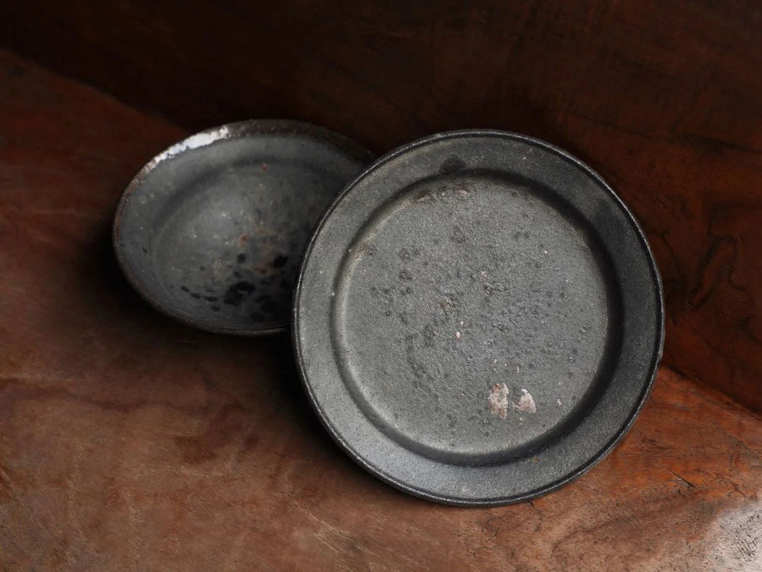 set of a bowl and plate handcrafted by Kan Ito on a woodern board with plate at the forefront