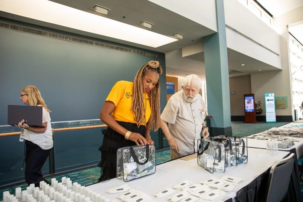 Three volunteers working on assembling toiletries bags for the homeless