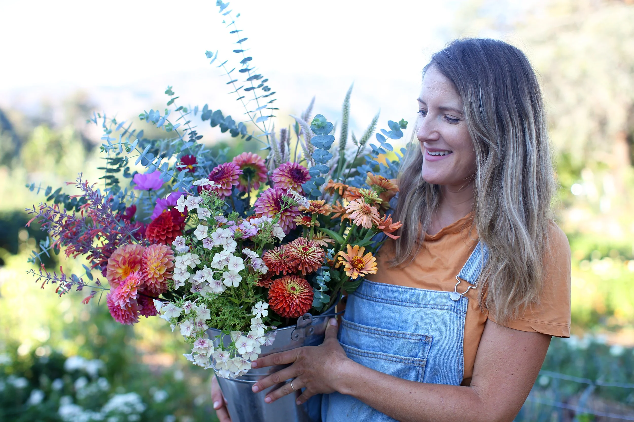 Farmer-Florist Jacky Surber holding a bucket of her fresh grown flowers