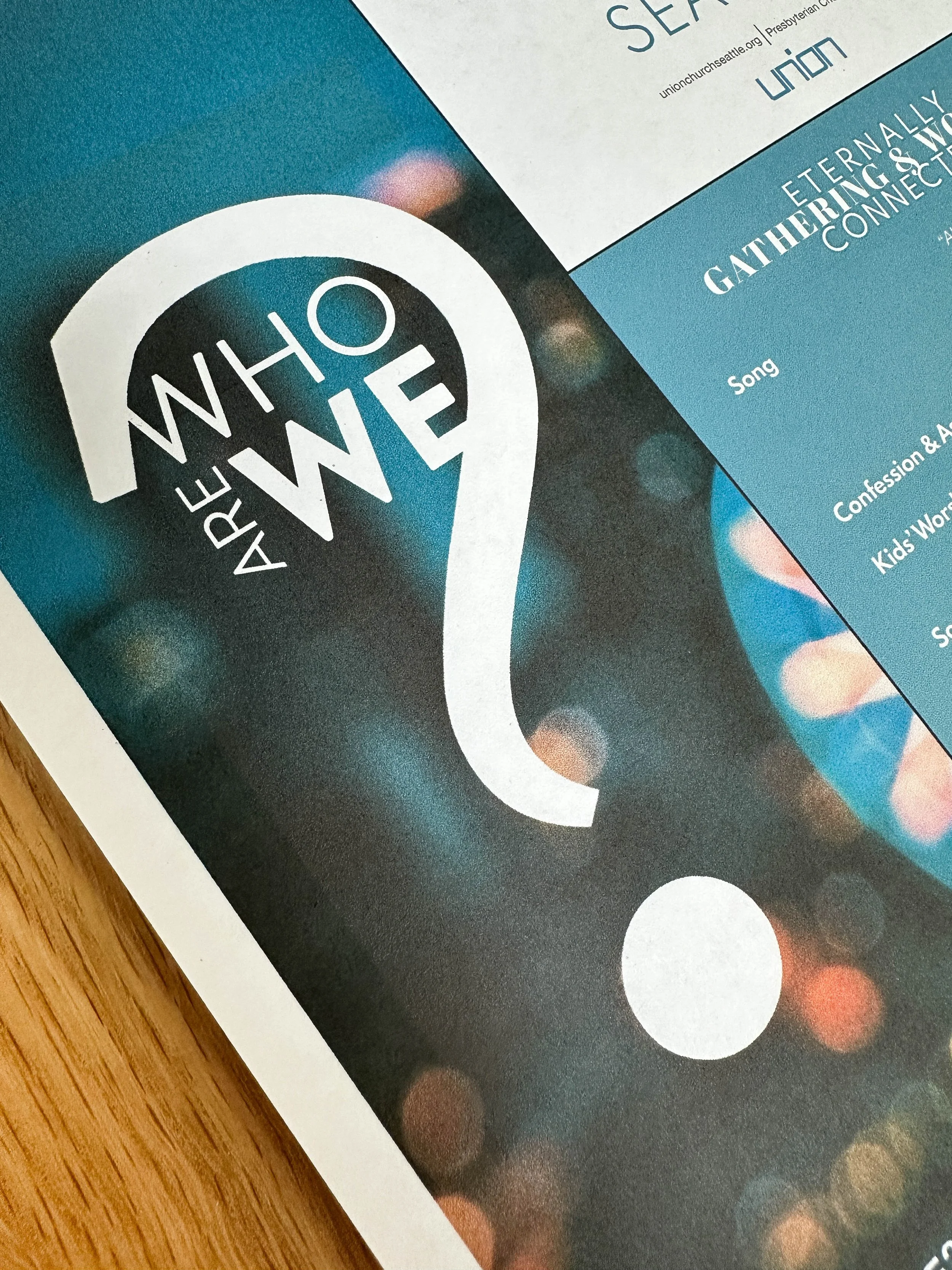 Logo "Who are we?" overlaying a blurry city image.