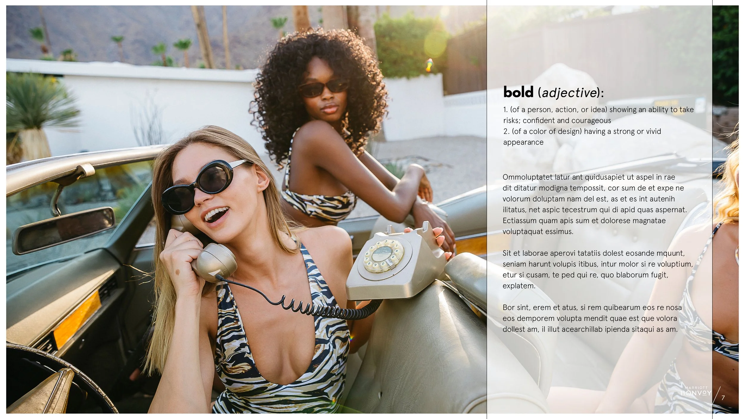 A woman in a leopard swimsuit sits in a convertible holding a rotodial phone while another woman looks on.