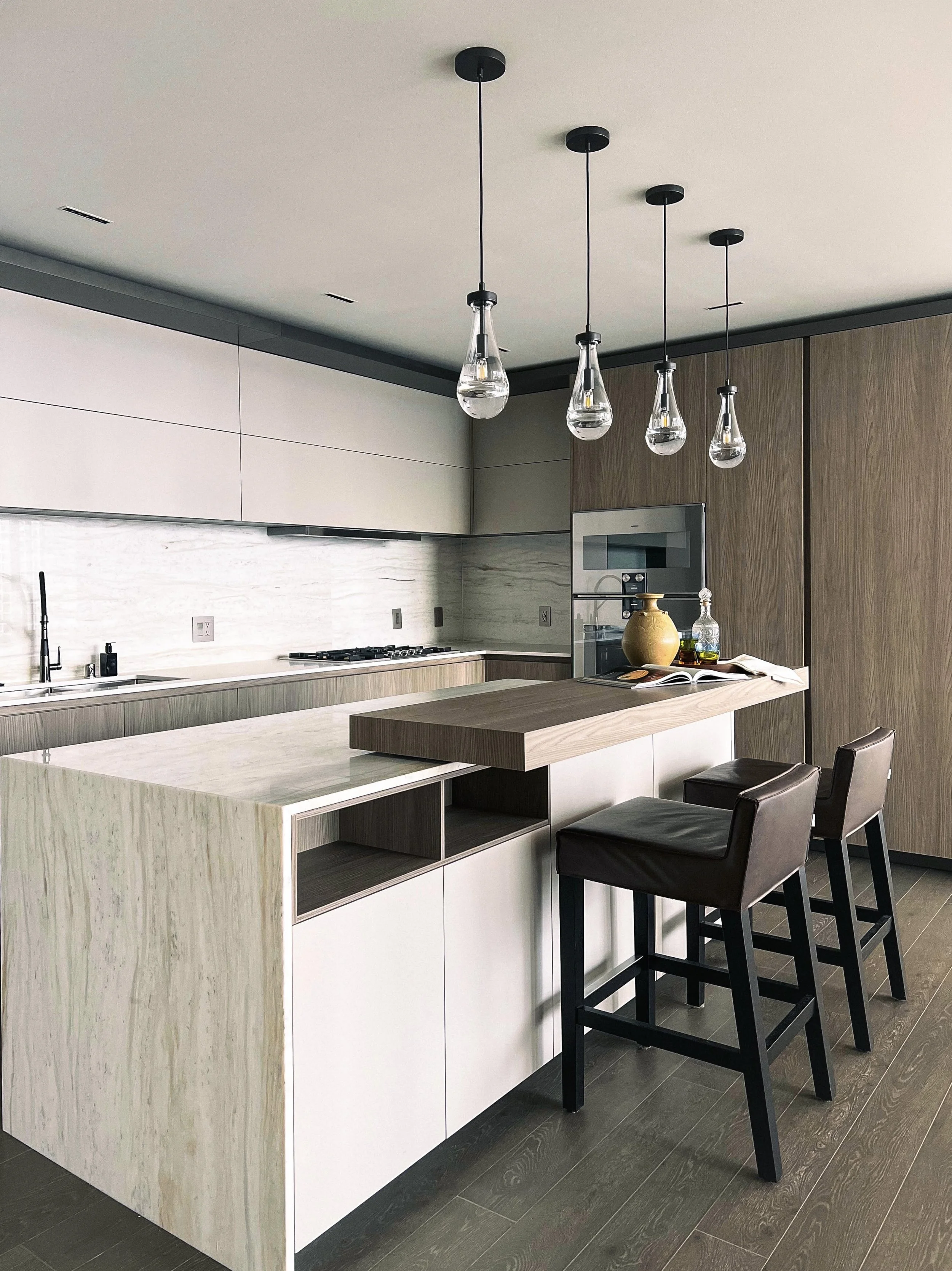 A kitchen island has two barstools up at the counter.