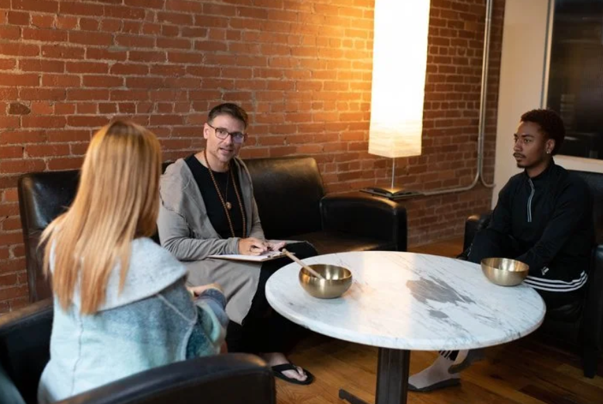a sound coacher coaching two students .