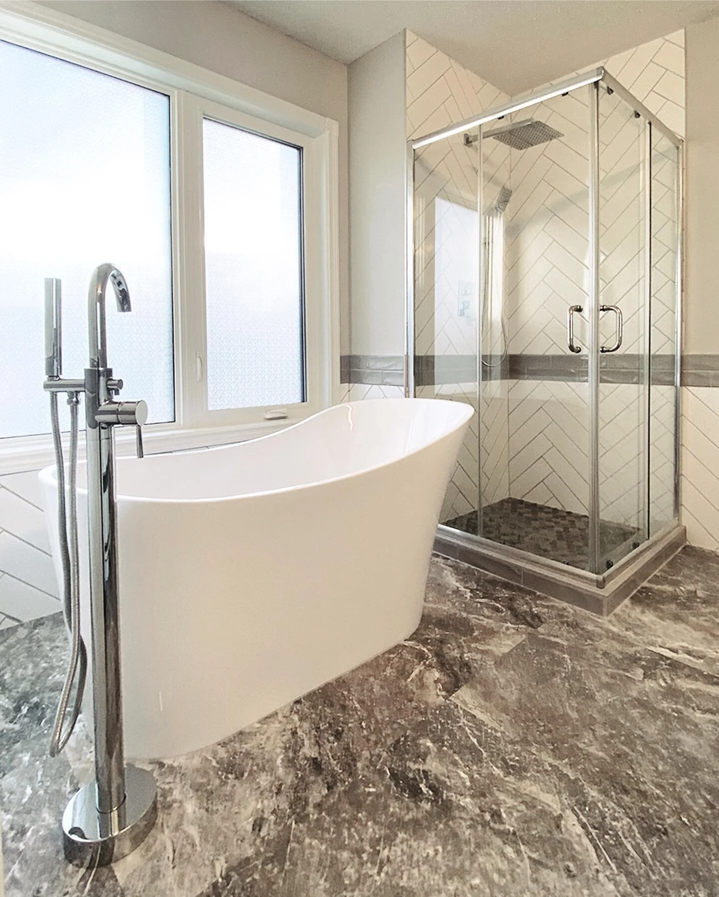 You just can&rsquo;t go wrong with herringbone tile, a fresh new shower, large grey floor tiles, and a deep soaker stand-alone tub! The clean colour palette and chrome features makes this full bathroom renovation an instant favourite of ours ♡

#yycb