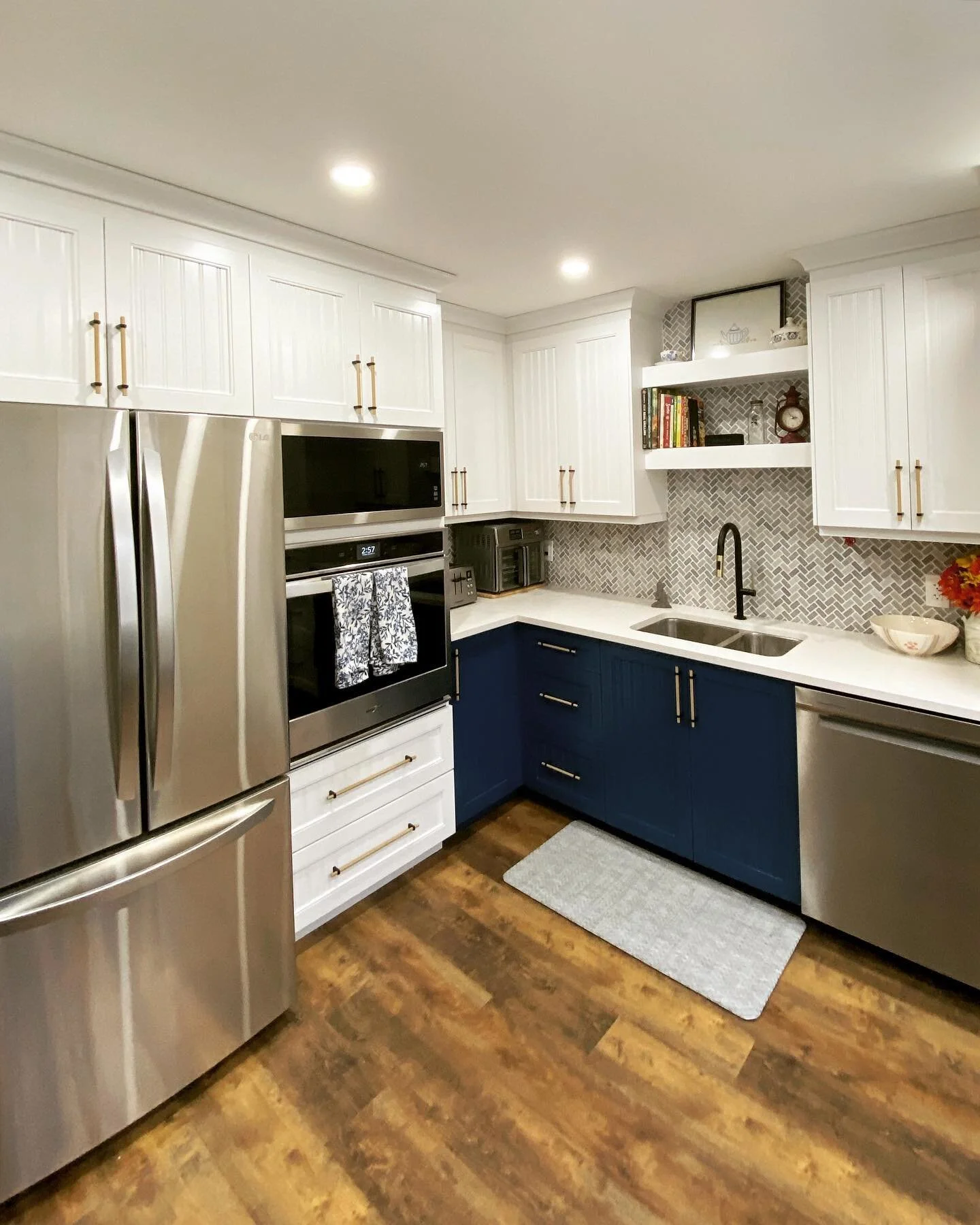 This stunning new kitchen is now finished! ✨ One of our favourite projects to date, the complete redo includes custom cabinetry with crown moulding, herringbone tile, gold/matte black handles and fixtures, new flooring, countertops, lighting, and mor