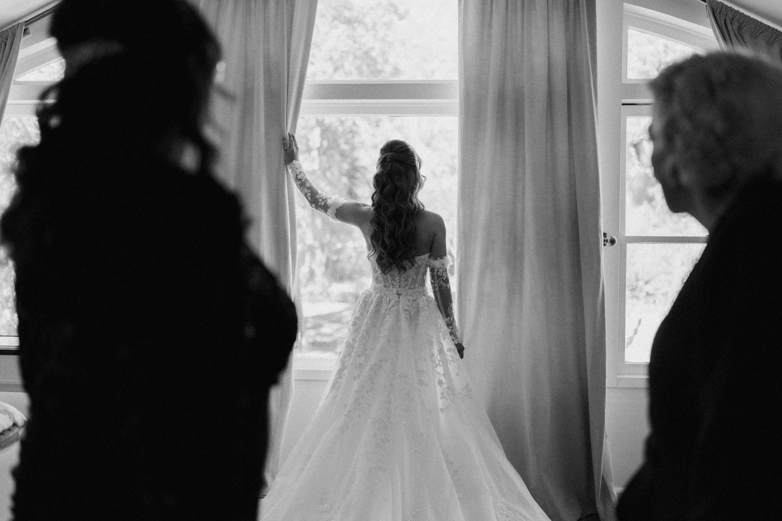 silhouette of a bride with parents looking at her 