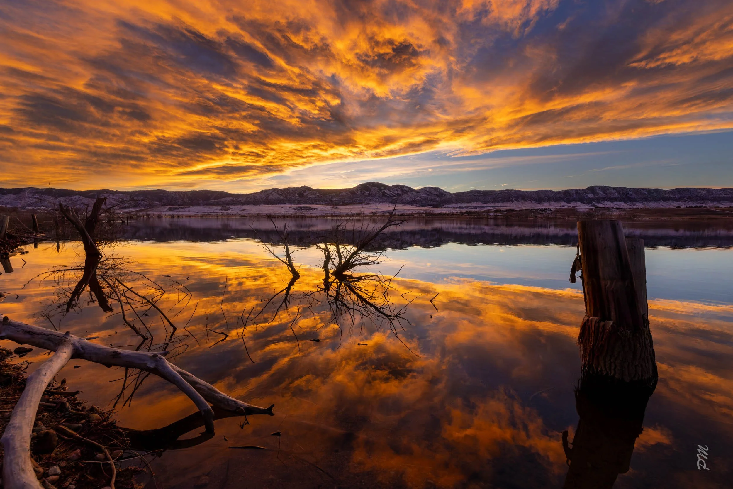 Colorful sunset with reflection of clouds in water at Chatfield State Park
