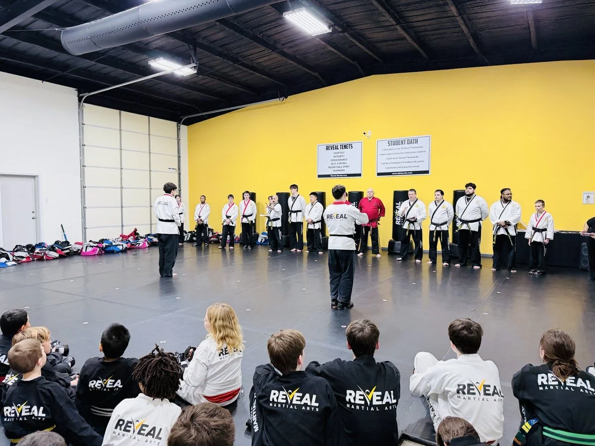 Two students standing in front of judges panel certifying for next level of martial arts instructor.