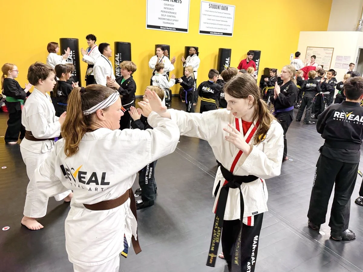 Two ladies practicing self-defense moves and eye focus during martial arts class at Reveal Martial Arts.