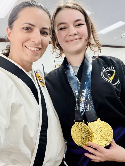 Two young women training martial arts and showing off their taekwondo tournament medals.