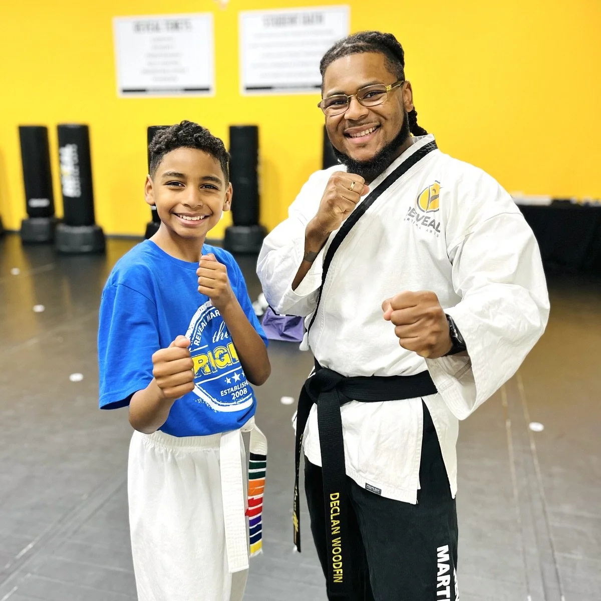 Reveal Martial Arts instructor posing with his student during karate class.