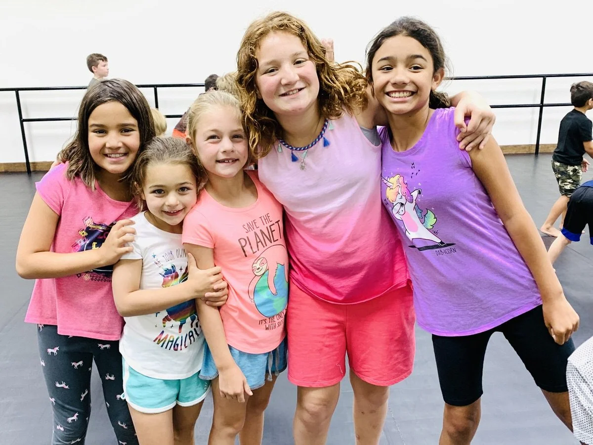 Group of smiling girls during summer camp at Reveal Martial Arts.