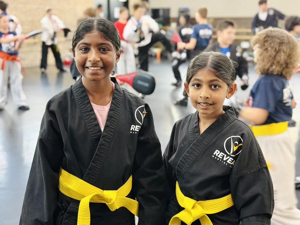 Two young students at Reveal Martial Arts during class, showing confidence, focus, and a positive training environment that supports success at school.