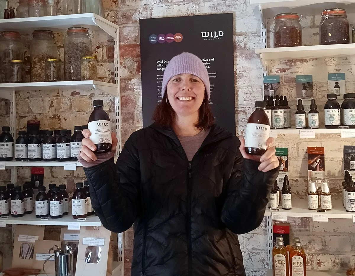 Pic of Ruth holding bottles in the shop