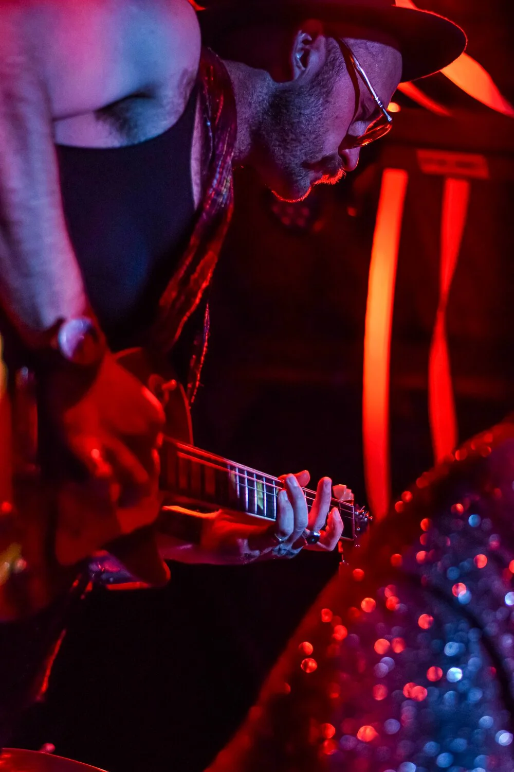 Live music photography. Band member playing guitar with hat on.
