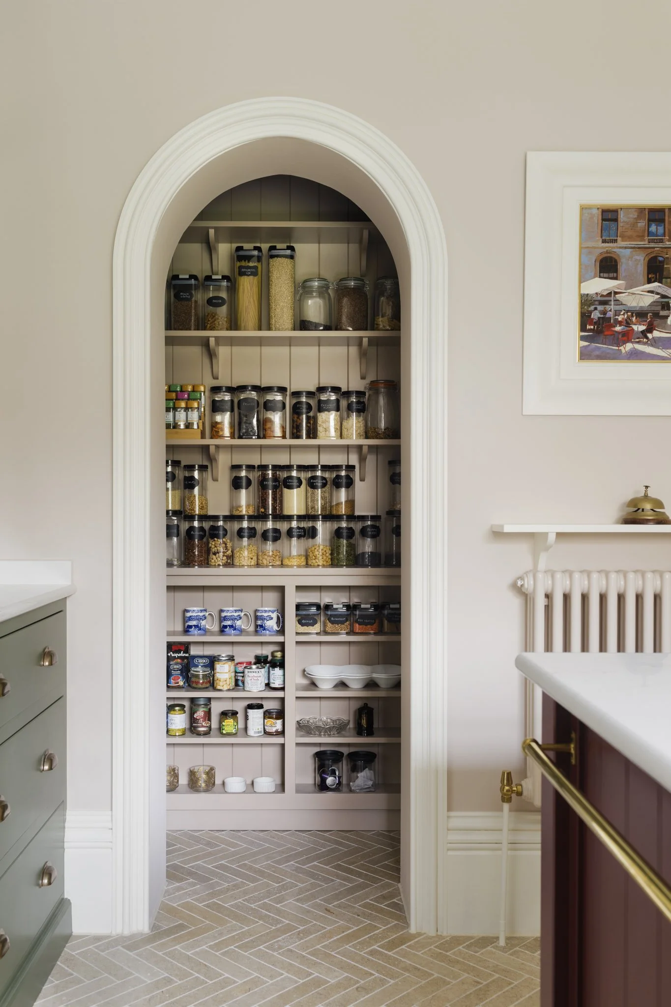 Pantry cabinet filled with spice jars, food containers, and kitchen supplies in a home kitchen.