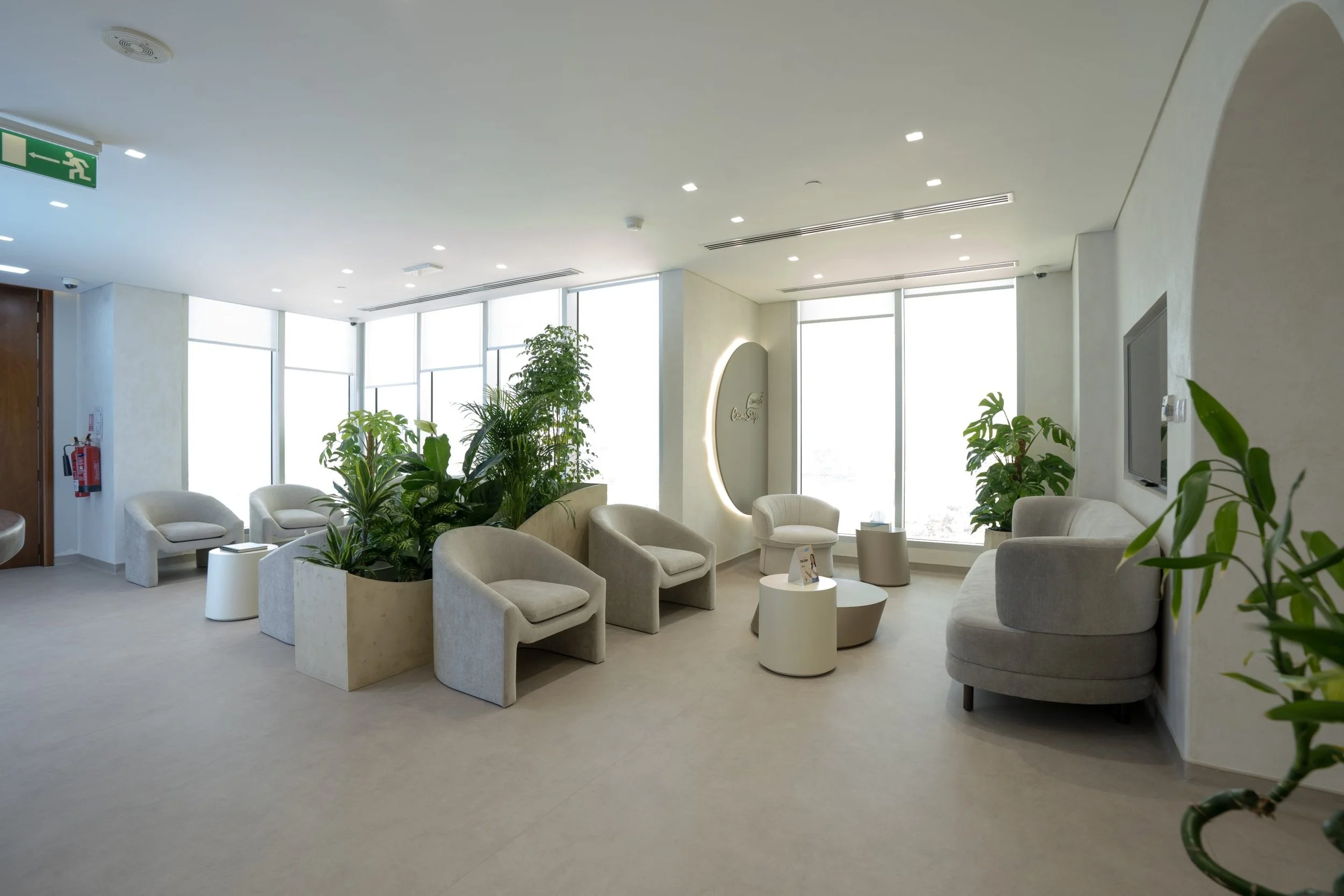 Modern interior waiting room of CosmeSurge Marina Dubai clinic with beige armchairs, a well-lit atmosphere, and large windows.