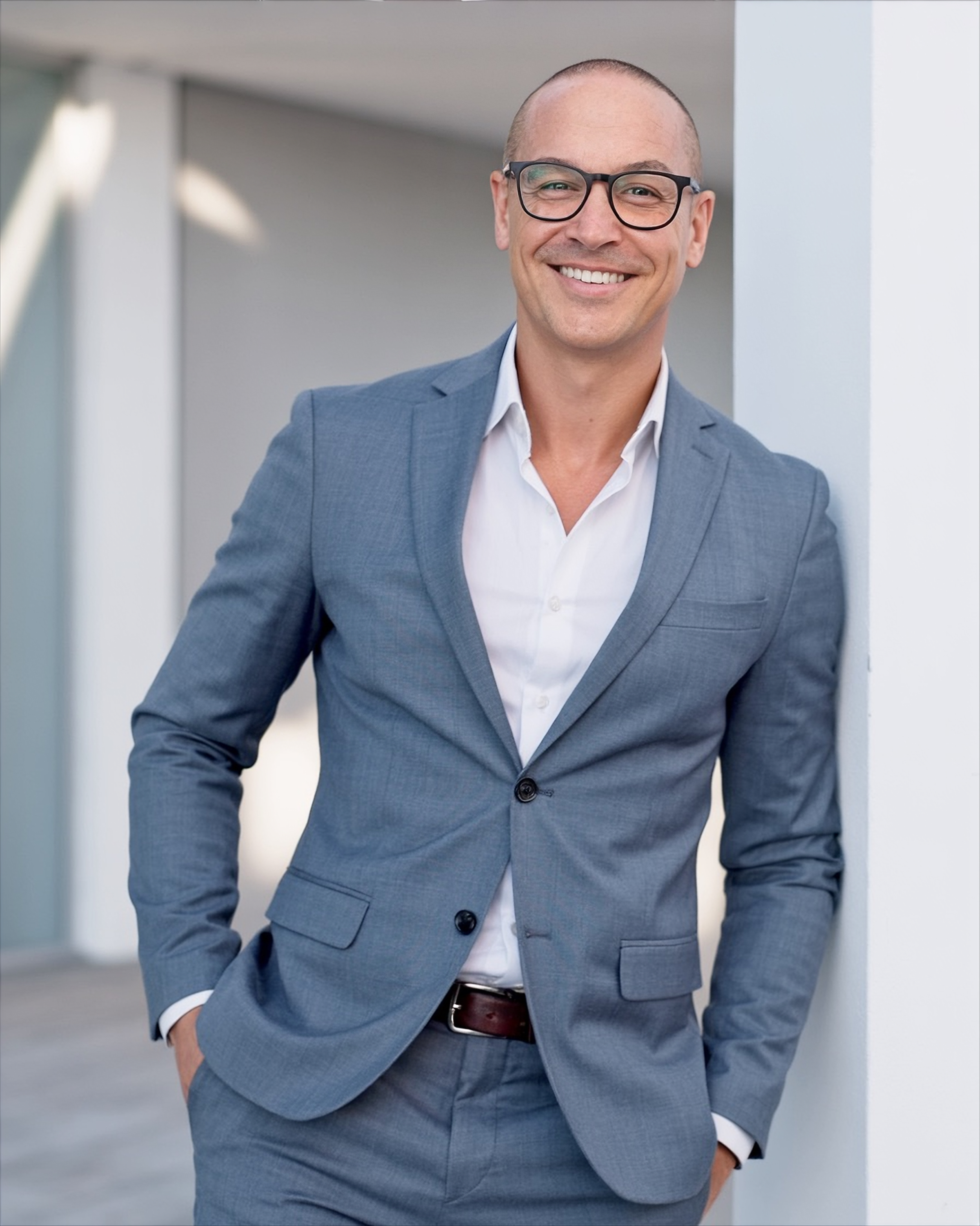David Hannan, career coach and former recruiter, standing in a grey suit and smiling in a professional setting