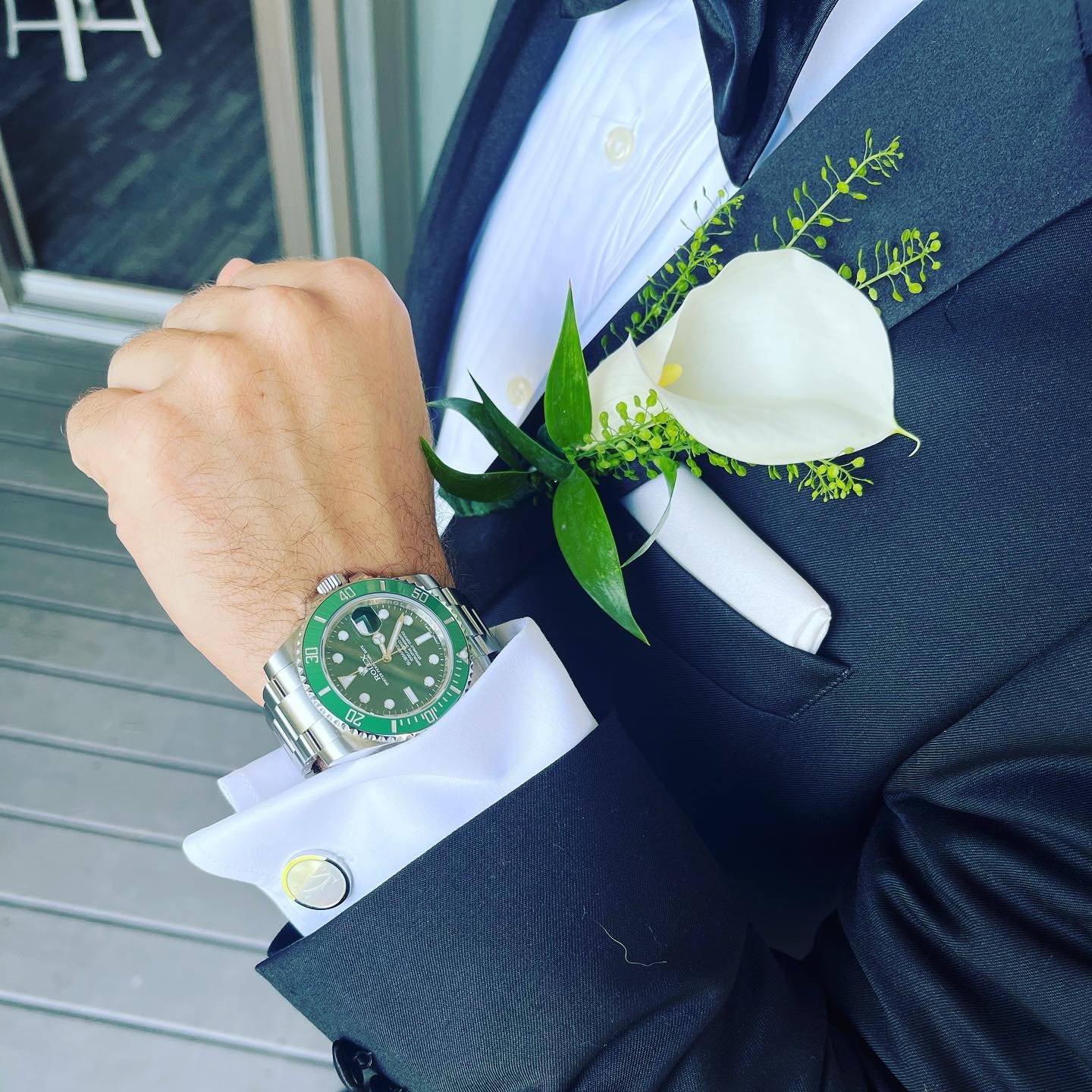 Man in formal suit with green watch and white calla lily boutonniere