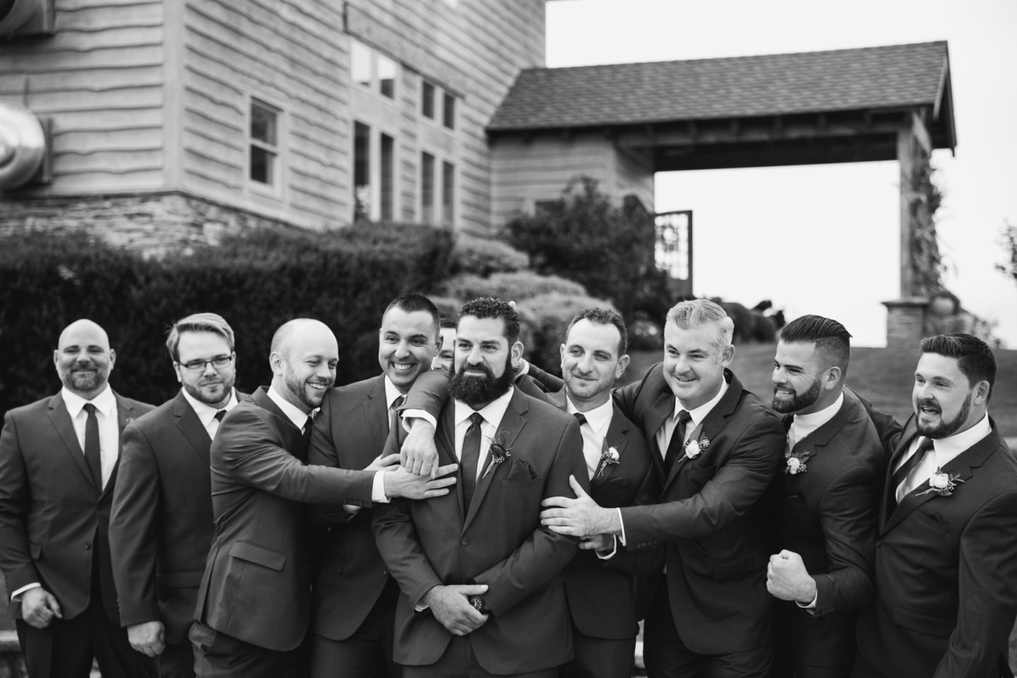 Groomsmen in suits posing together outdoors