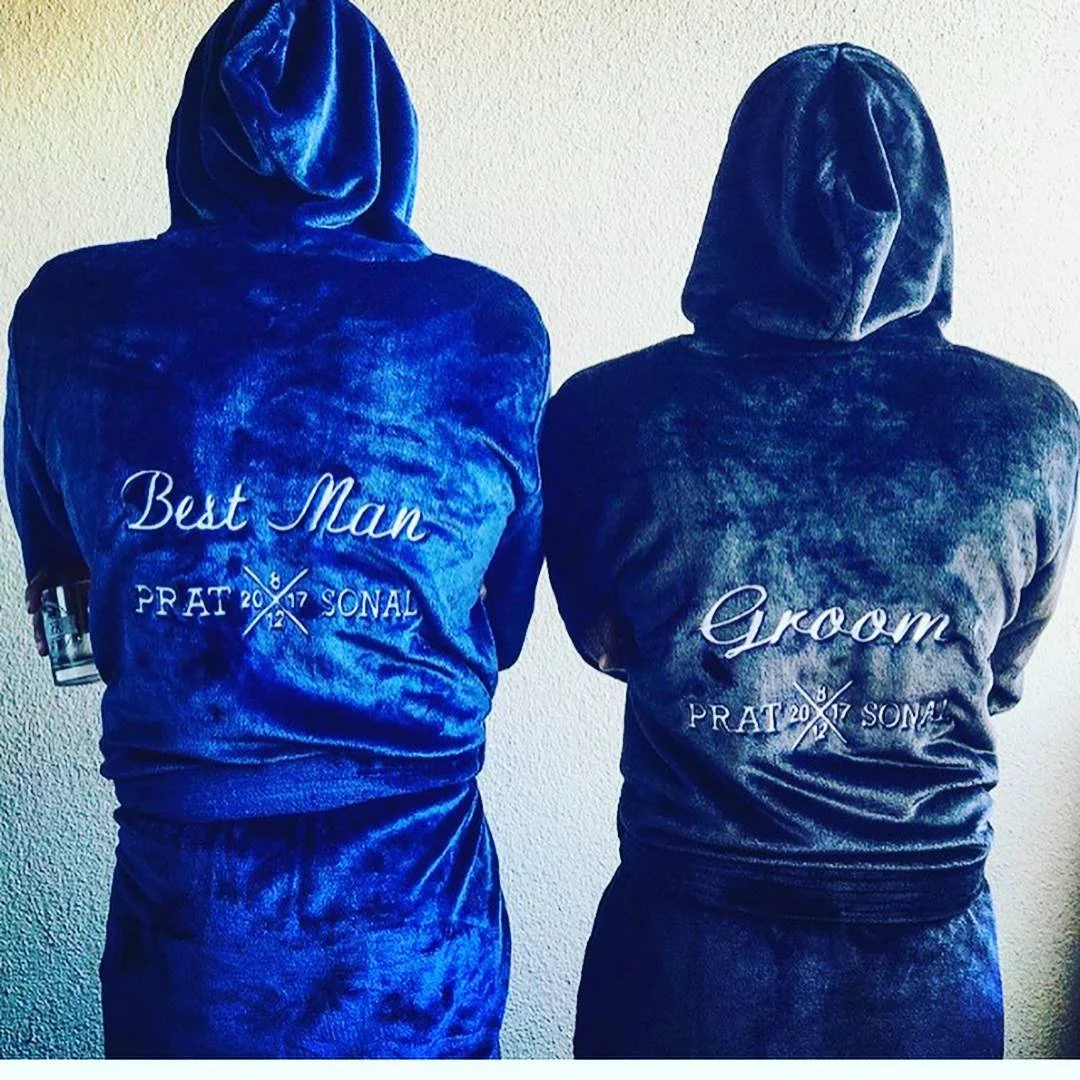 Two people wearing hooded robes with "Best Man" and "Groom" embroidered on the back.