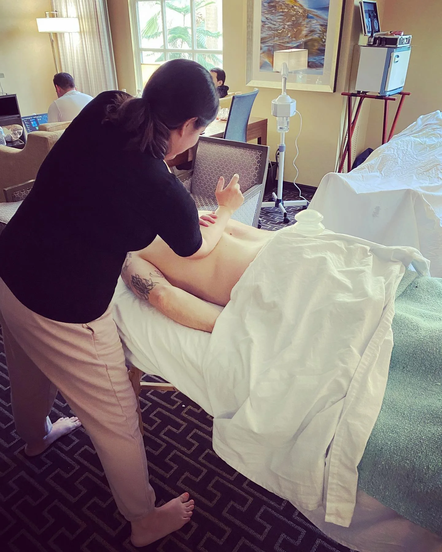 Person receiving a massage in a room with a massage therapist