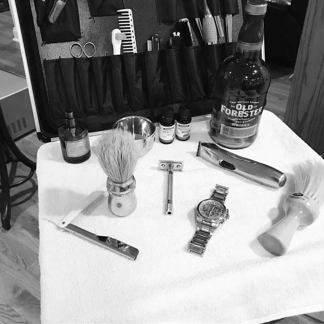 Shaving kit with razor, brush, and grooming tools on white cloth