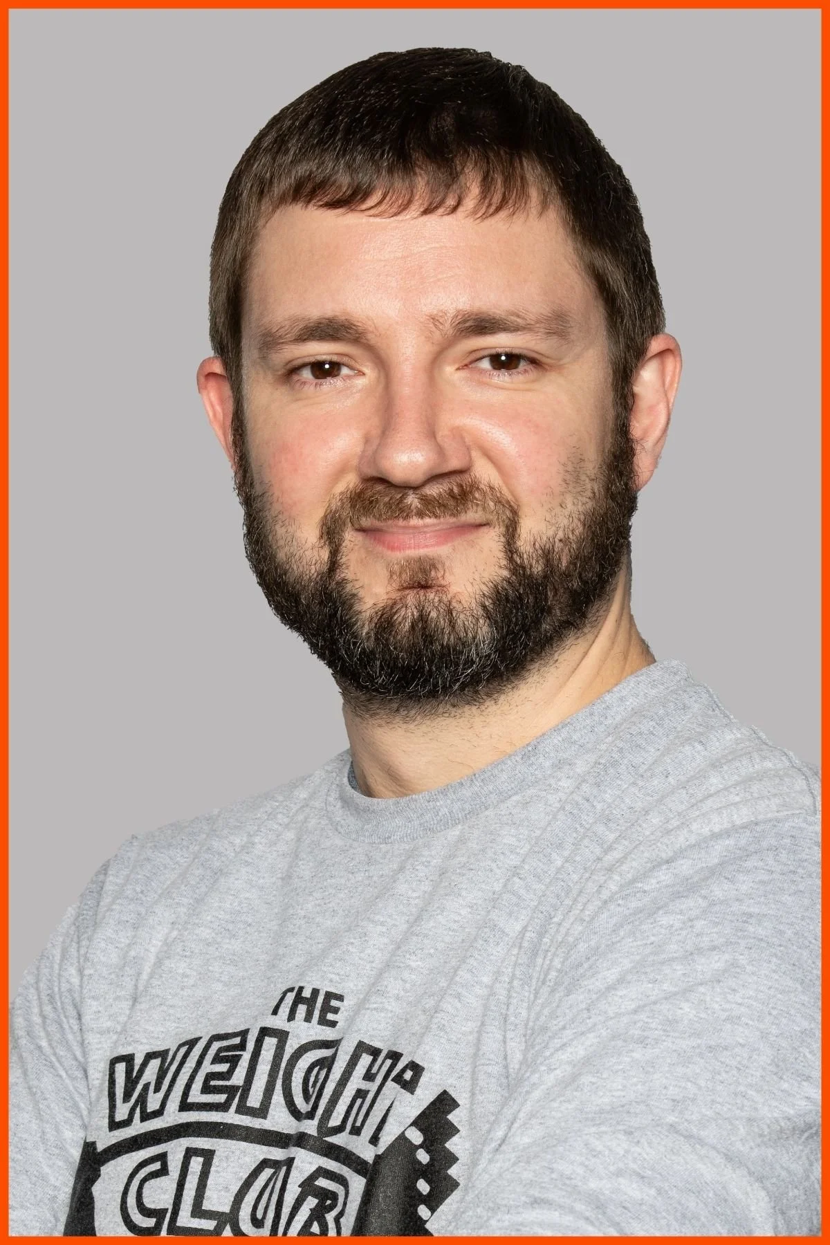 A portrait of The Weight Club front desk supervisor, Jaime Waterman, wearing a grey weight club shirt with The Weight Club logo.