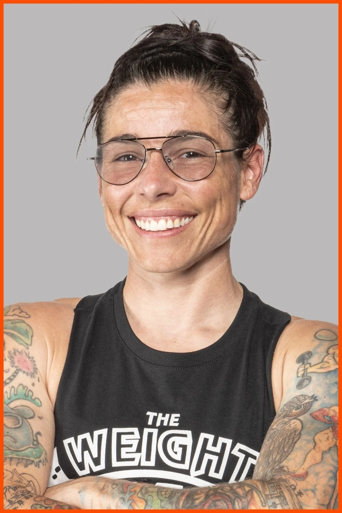 A portrait of The Weight Club facilities manager, Sydney Herbol, wearing a black weight club tank-top with The Weight Club logo.