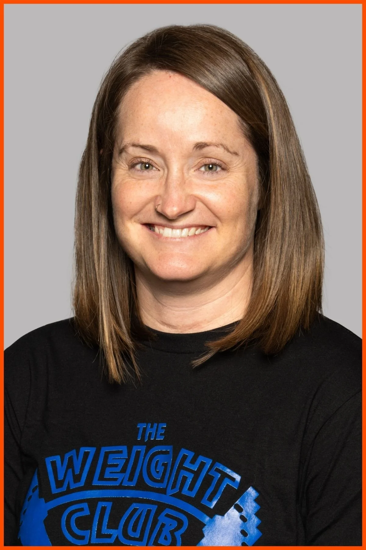 A portrait of The Weight Club Group Fitness Director, Megan Evans, wearing a black weight club shirt with The Weight Club logo.