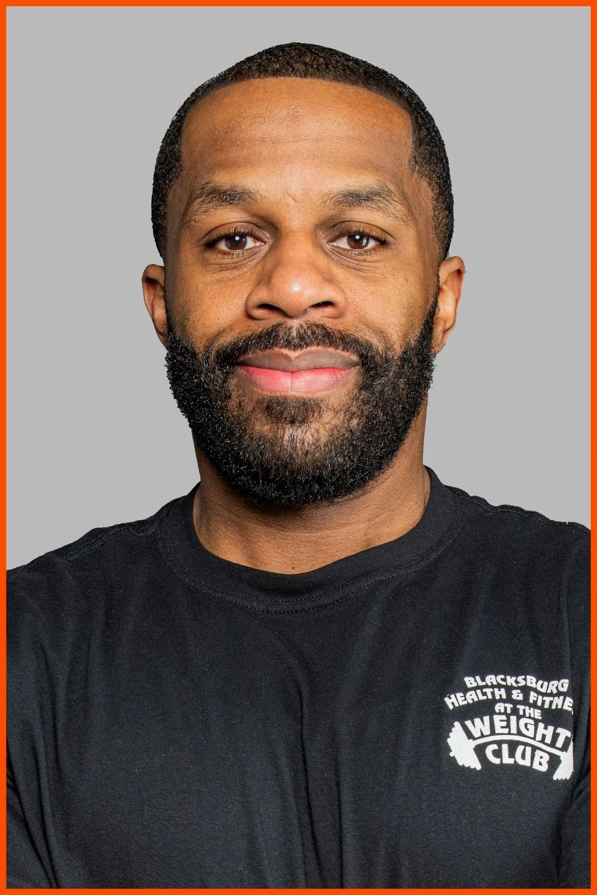 A portrait of The Weight Club supplements manager, Jon Booth, wearing a black weight club shirt with The Weight Club logo.