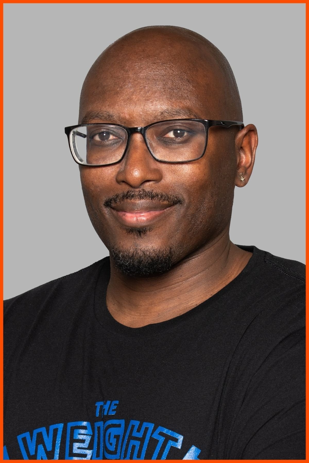 A portrait of The Weight Club general manager, Dewayne Moore wearing a black weight club shirt with The Weight Club logo.