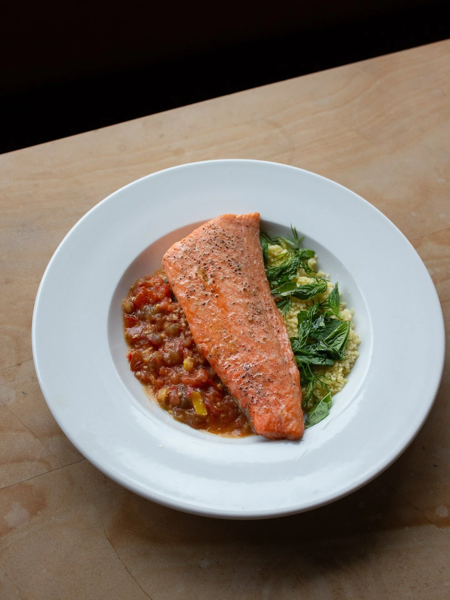 On the menu at Margot —  Roasted Faroe Islands salmon over couscous with grated tomato vinaigrette, preserved lemon, chili, and black pepper.