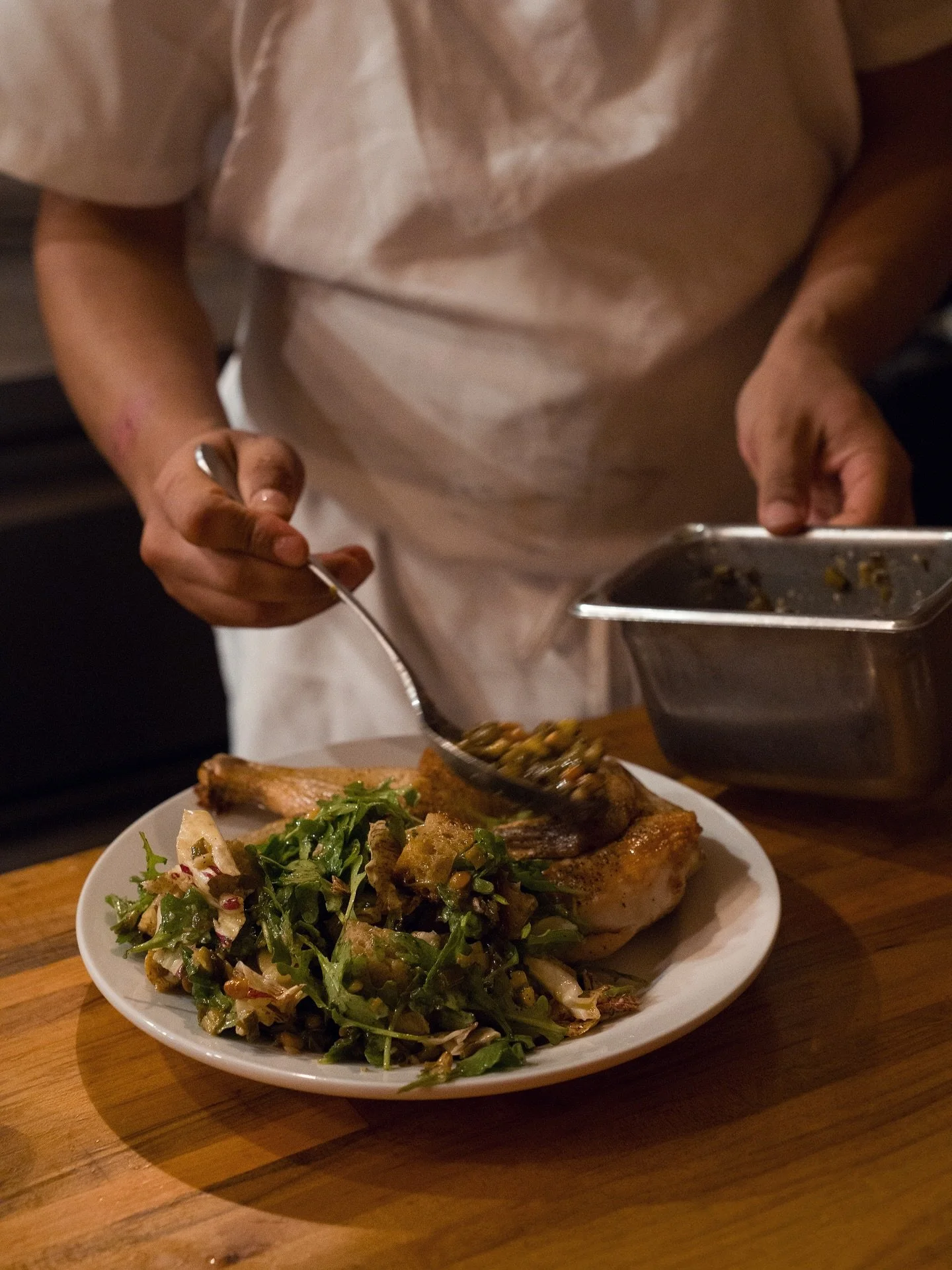 Zuni Chicken &mdash; koji-brined for savory, crisp golden skin and juicy meat, roasted with herbs and orange. Served with a bright panzanella salad of garlic toasted bread, arugula, radicchio, and currants.