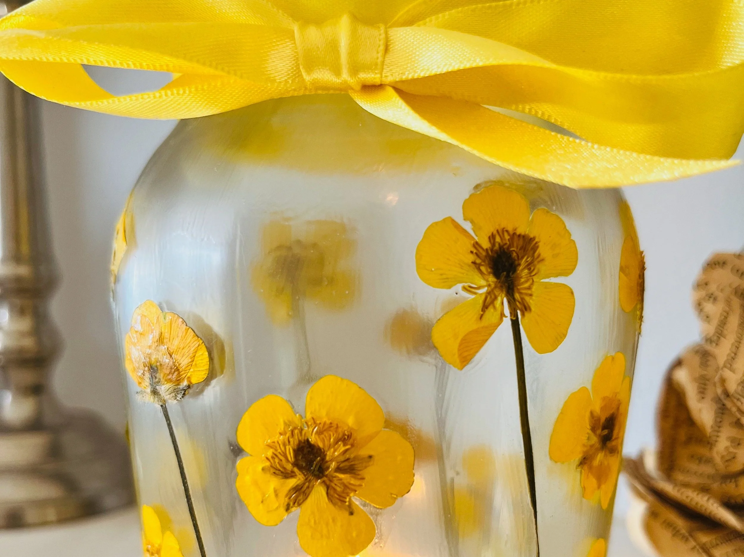 pressed yellow buttercup flowers sealed to tea light jar