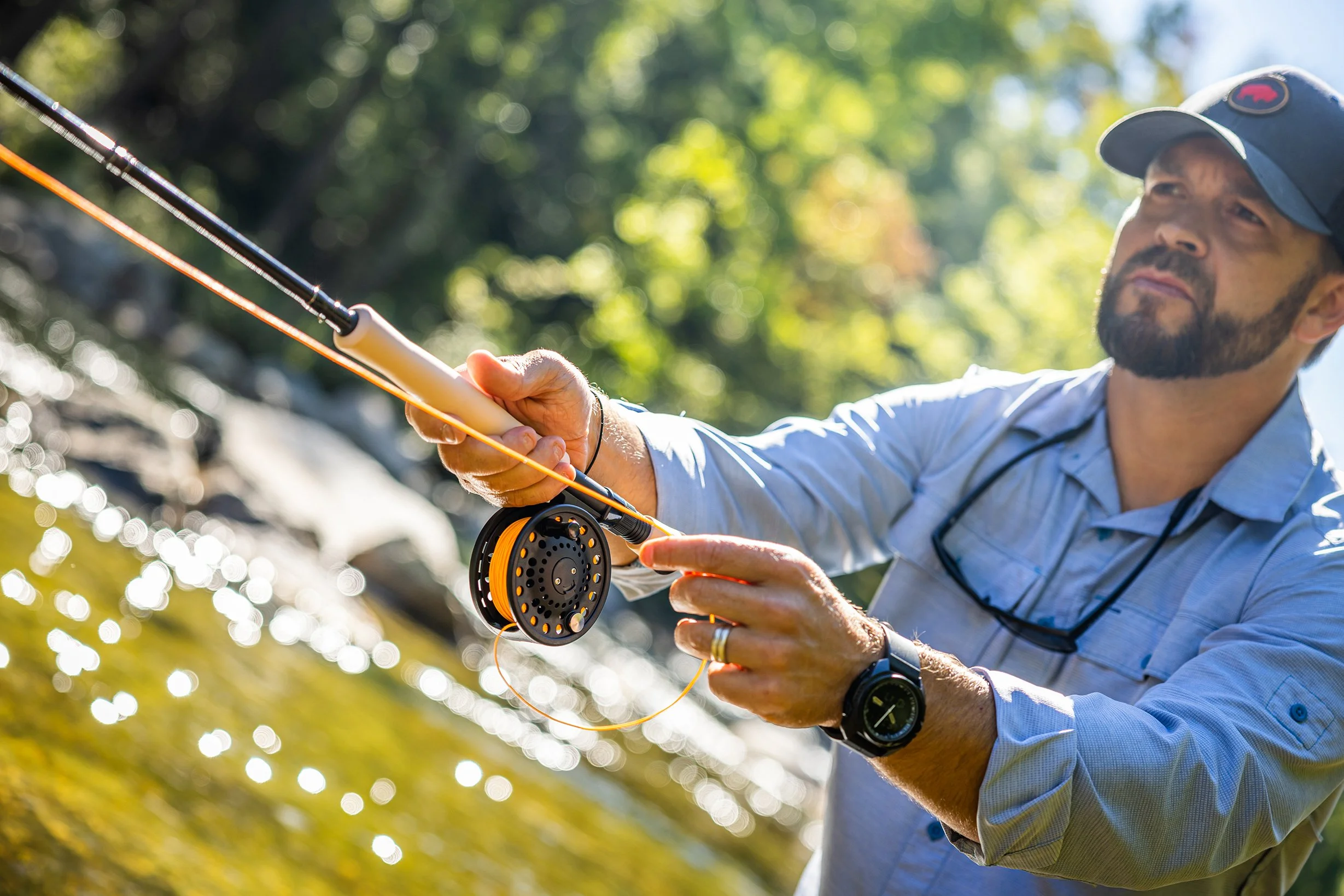 Man fly fishing in a river, holding a fishing rod