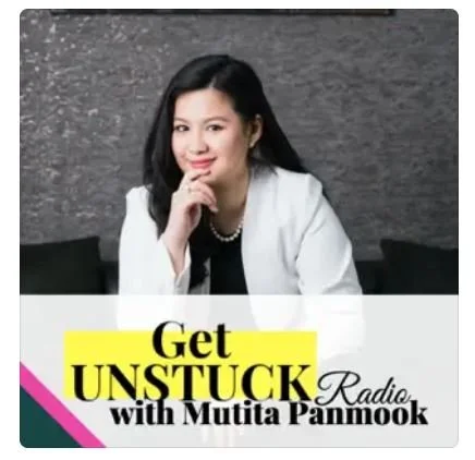 A woman with long black hair, wearing a white blazer, sitting in front of a dark background, promoting a radio show called 'Get Unstuck with Mutita Panmook'.