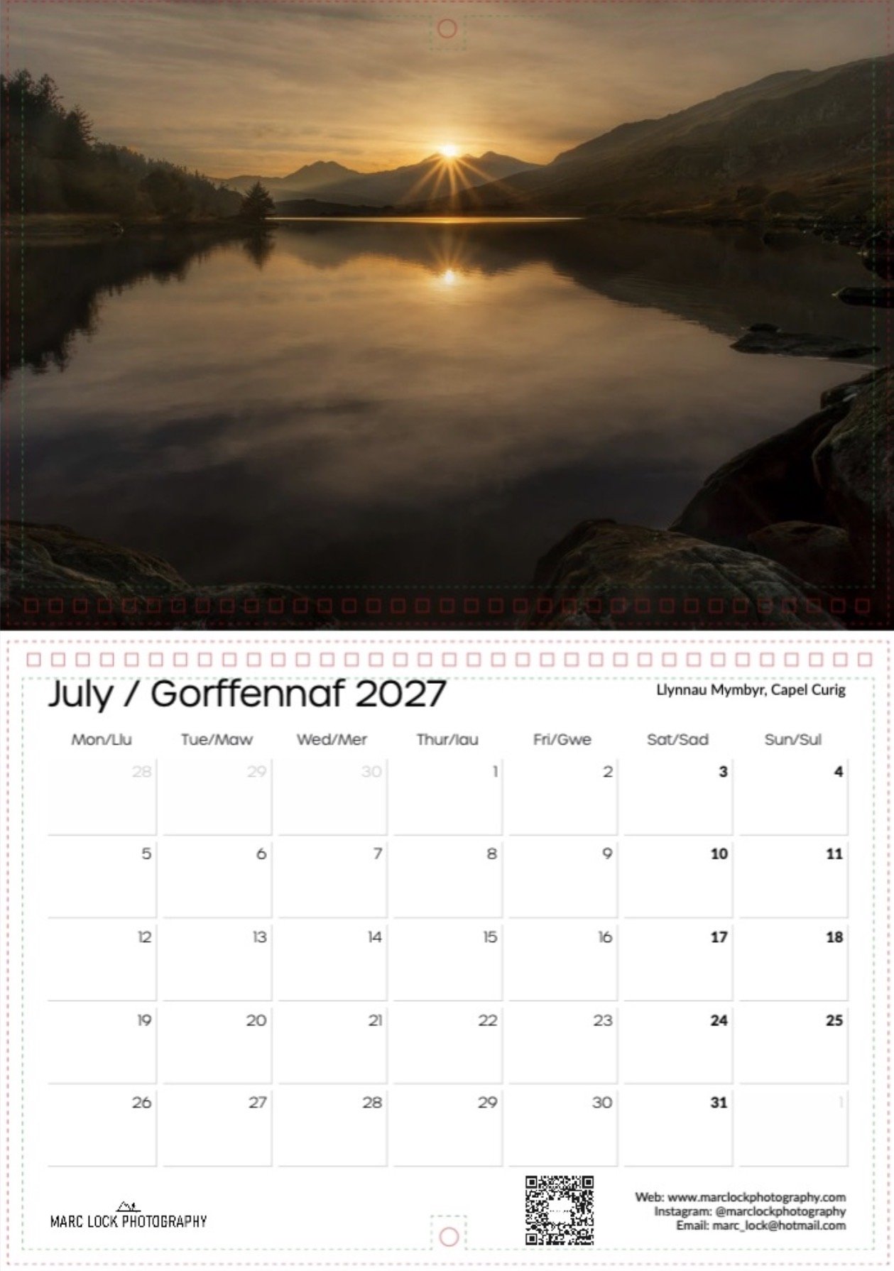 A calendar page for July 2027 with a scenic photograph of a sunset over mountains and a calm lake, reflecting the sky and landscape.
