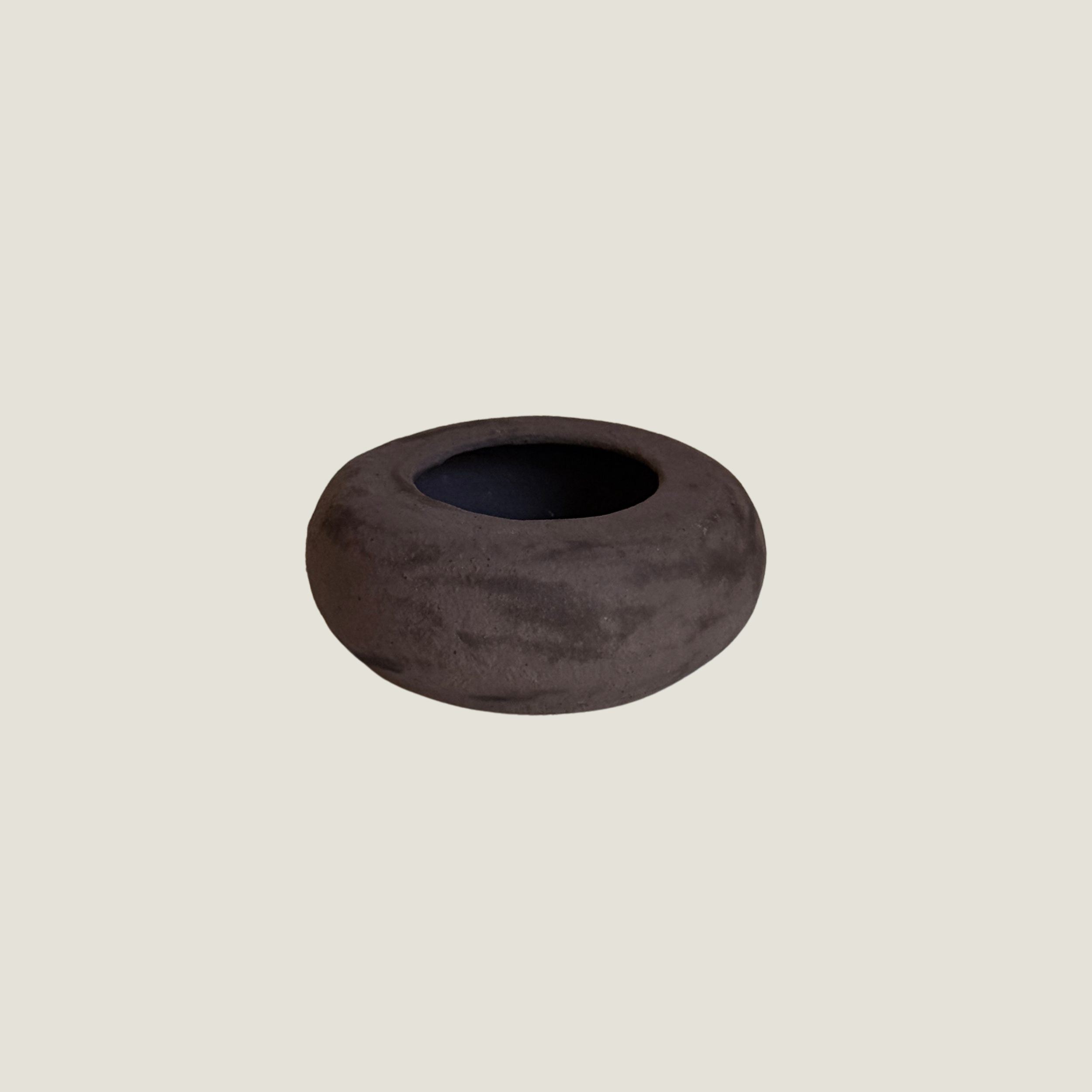 Low rounded dark brown matte ceramic vessel shaped like a river stone with a small opening and black interior