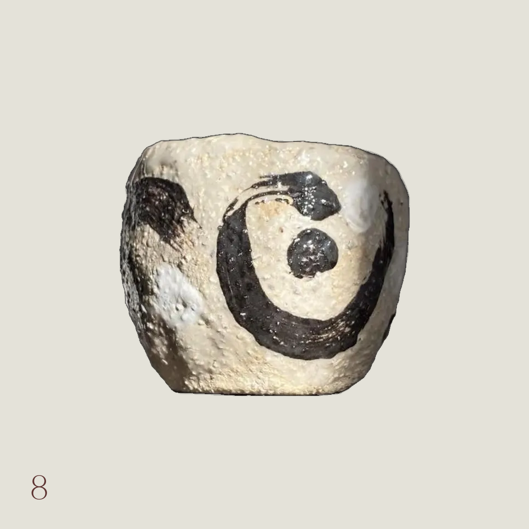 Handmade wabi-sabi yunomi tea cup in textured cream stoneware with black brushstroke spiral