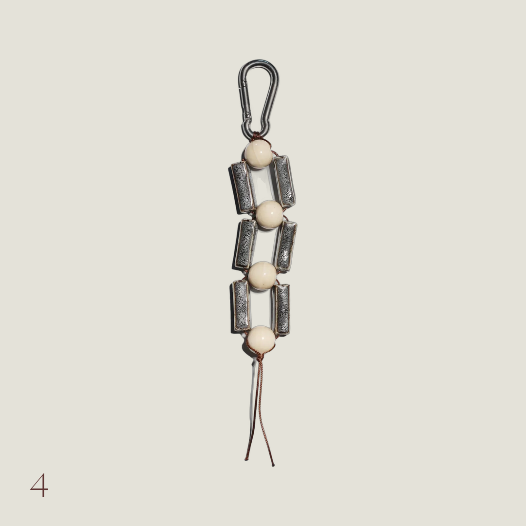 Strand keychain bag charm with speckled grey glazed tubes and cream beads on a silver carabiner