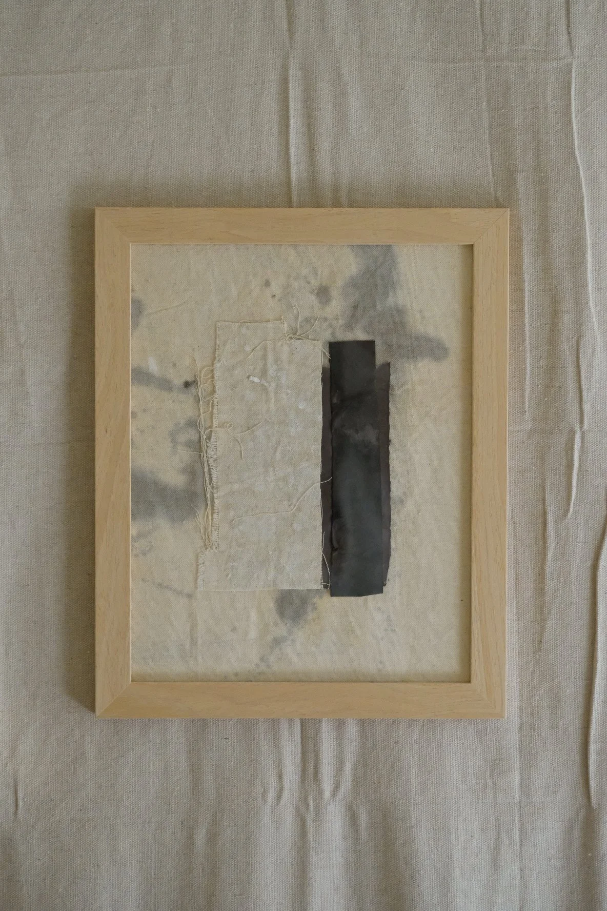 Framed 11 x 14 collage of a cream canvas strip beside a tall charcoal paper strip