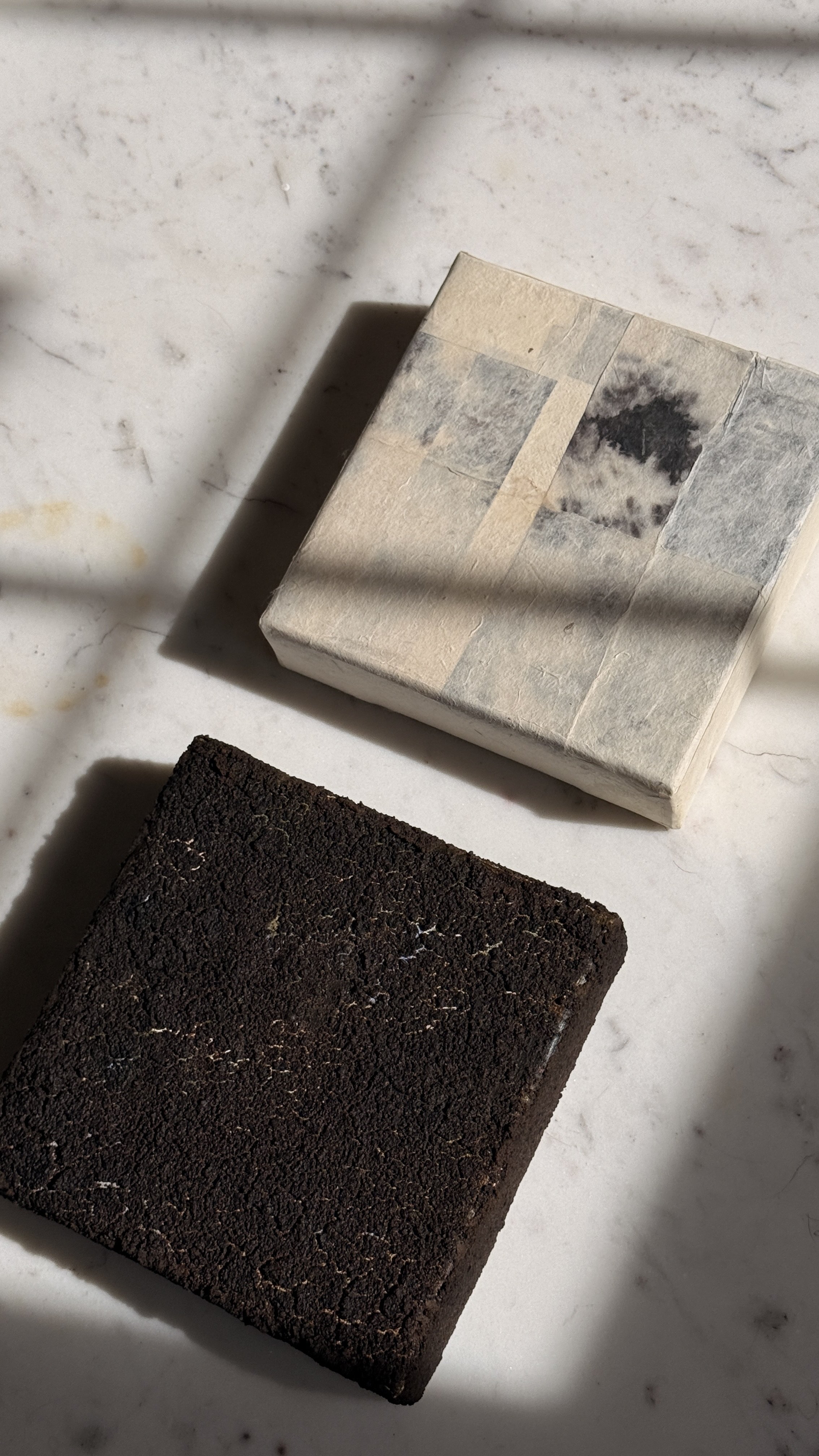 Small abstract artwork with a dense, cracked dark brown and black textured surface and faint pale veining, unframed 6x6 on linen