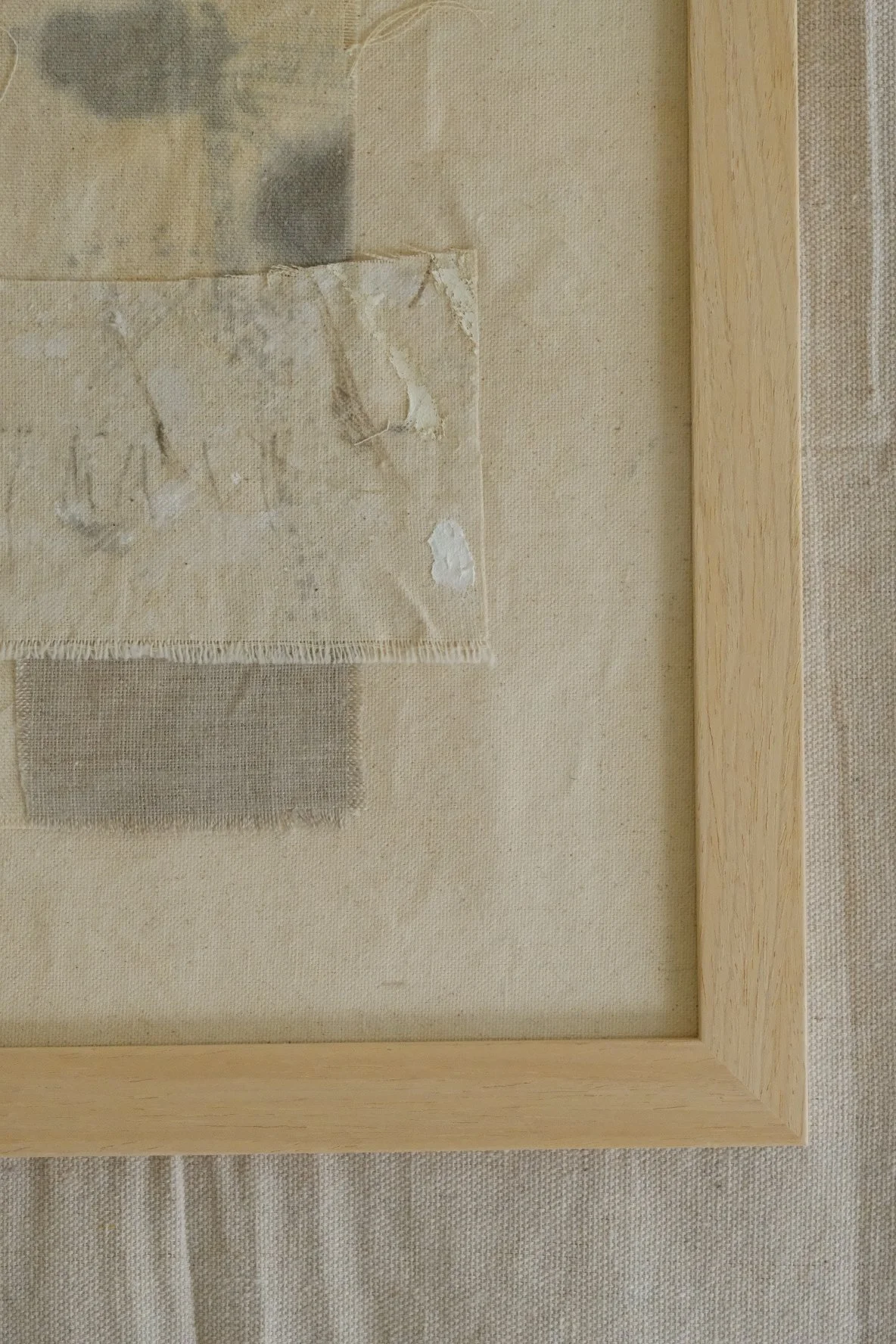 Framed 11 x 14 collage of layered canvas panels and a grey cloth patch with soft grey marks